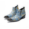 Pair of men's blue and gold splatter ankle boots with shiny metal toe caps and side zippers on a white background.