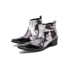 Pair of Aomishoes men's newspaper print ankle boots with pointed patent leather toe caps and side zippers on a white