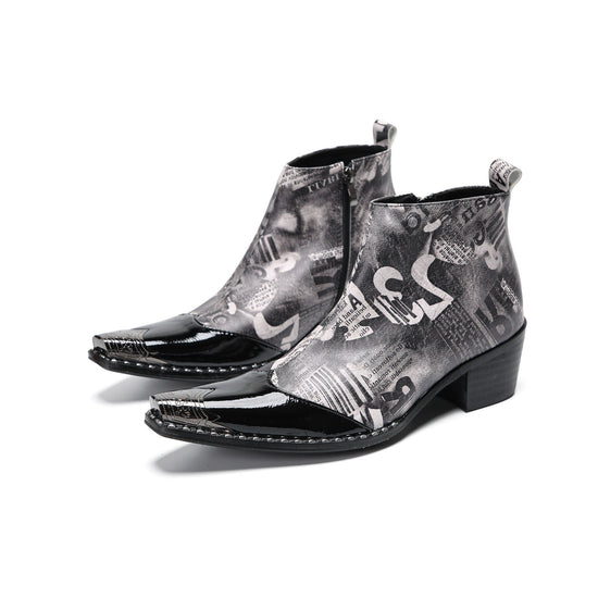 Pair of men's black and white newspaper print ankle boots with patent leather pointed toes and studded details.