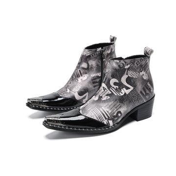 Pair of men's black and white newspaper print ankle boots with patent leather pointed toes and studded details.