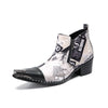 A pair of men's black and white newspaper print ankle boots with a pointed metal toe, side zipper, and block heel.