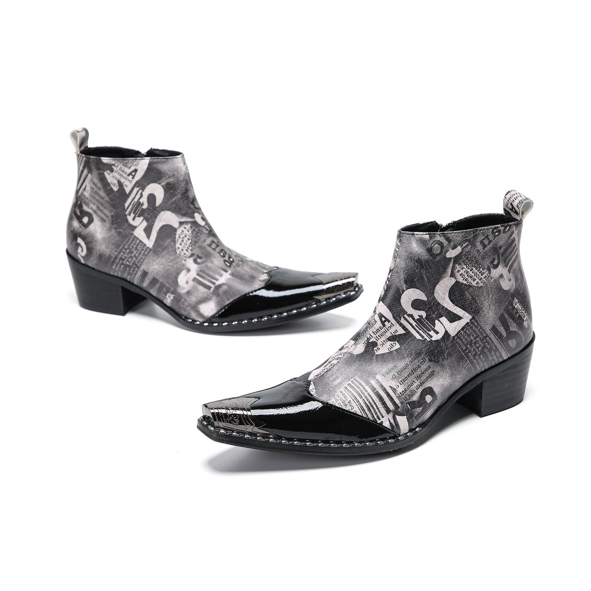 Pair of men's black and white newspaper print ankle boots with patent leather pointed toes and studded details.