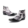 Pair of Aomishoes men's newspaper print ankle boots with pointed patent leather toe caps and side zippers on a white