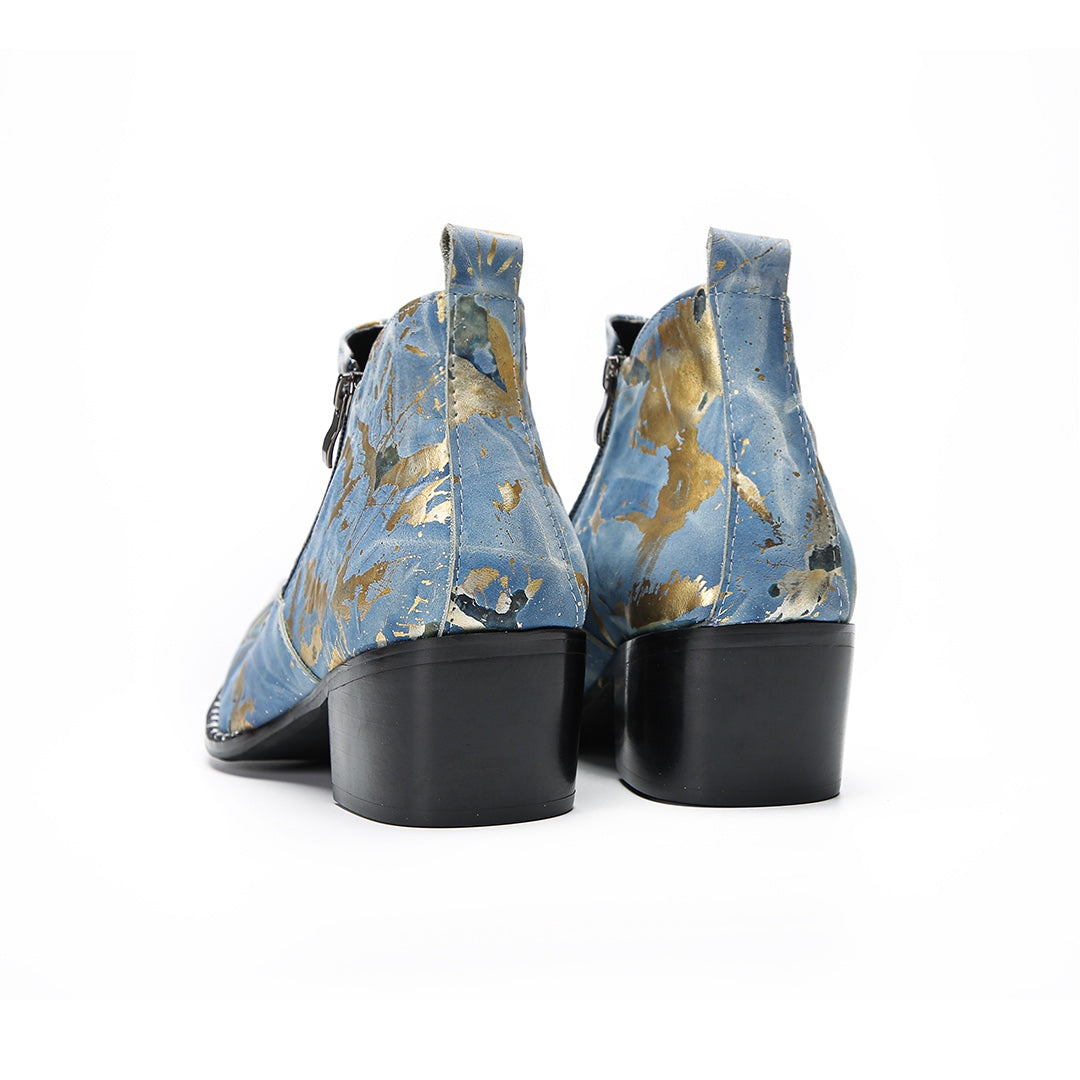 Pair of men's blue and gold splatter ankle boots with shiny metal toe caps and side zippers on a white background.