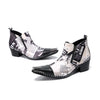 A pair of men's black and white newspaper print ankle boots with a pointed metal toe, side zipper, and block heel.