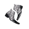 Pair of men's black and white newspaper print ankle boots with patent leather pointed toes and studded details.