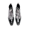 Pair of men's black and white newspaper print ankle boots with patent leather pointed toes and studded details.