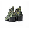 A pair of men's green and black patterned ankle boots with pointed metal toes and side zippers.