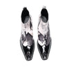 Pair of Aomishoes men's newspaper print ankle boots with pointed patent leather toe caps and side zippers on a white