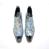 Pair of men's blue and gold splatter ankle boots with shiny metal toe caps and side zippers on a white background.