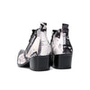 A pair of men's black and white newspaper print ankle boots with a pointed metal toe, side zipper, and block heel.