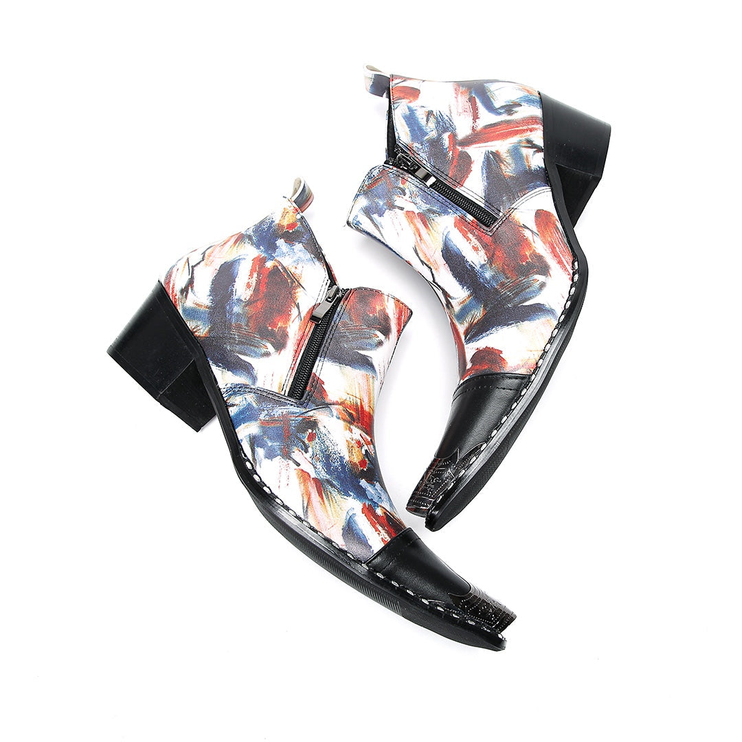 Pair of men's abstract print ankle boots with black leather pointed toe and metal tip, side zippers, and black block heels.