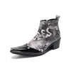 Pair of men's black and white newspaper print ankle boots with patent leather pointed toes and studded details.