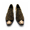 A pair of men's black studded loafers with a gold metal toe cap, a gold and grey patterned upper, and a crystal-embellished