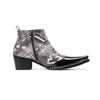 Pair of men's black and white newspaper print ankle boots with patent leather pointed toes and studded details.